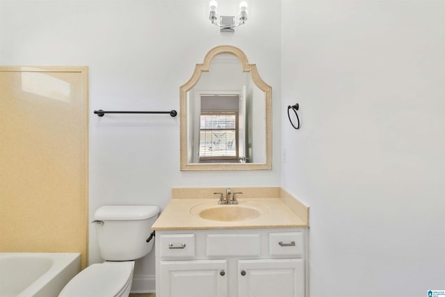 bathroom featuring vanity, a bathing tub, and toilet