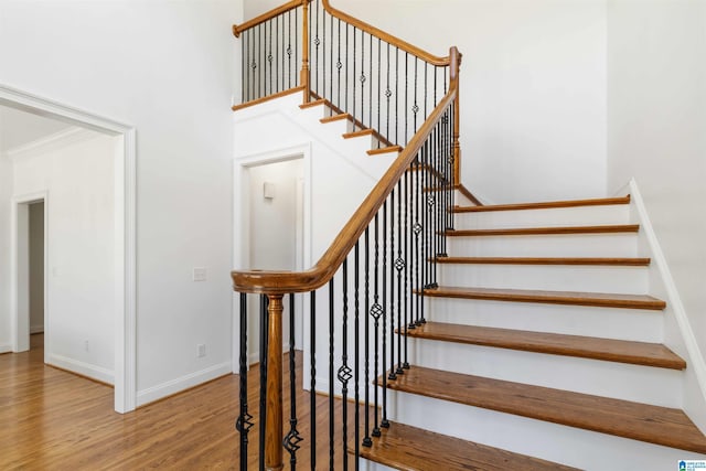 staircase featuring hardwood / wood-style flooring and crown molding