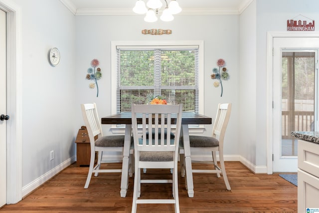 dining space featuring crown molding, hardwood / wood-style flooring, and an inviting chandelier