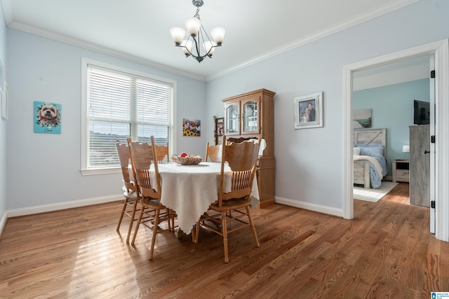 dining room with dark hardwood / wood-style flooring, ornamental molding, and a chandelier