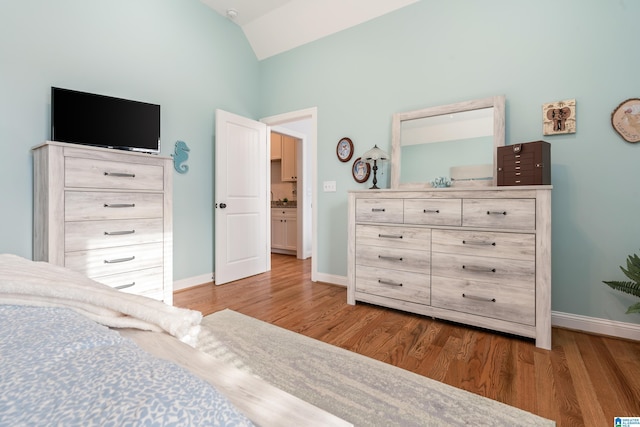 bedroom with vaulted ceiling and hardwood / wood-style floors