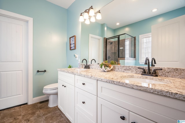 bathroom with vanity, toilet, and a shower with shower door