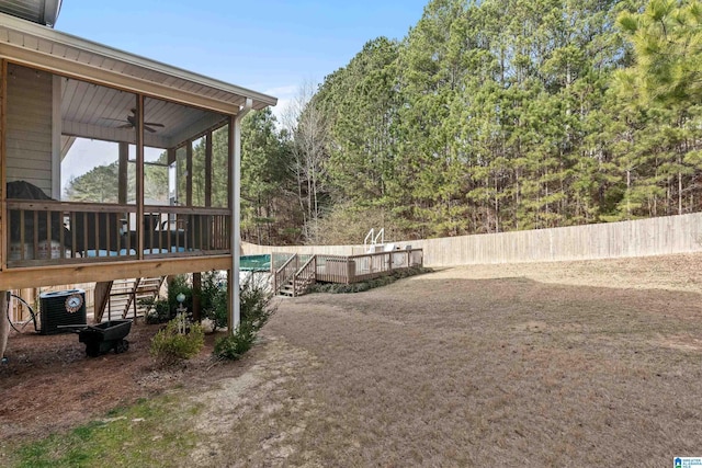 view of yard featuring central AC, ceiling fan, and a deck