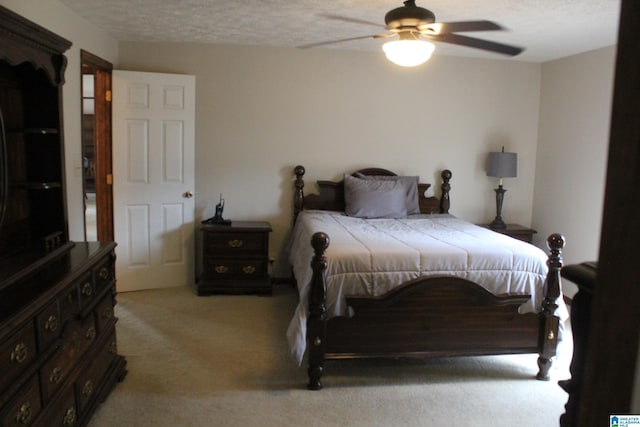 bedroom featuring ceiling fan, light carpet, and a textured ceiling