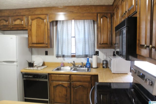 kitchen featuring sink, a textured ceiling, and black appliances