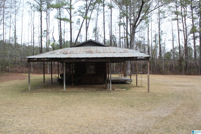 view of outdoor structure with a lawn and a carport