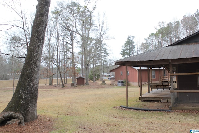 view of yard with a shed, central air condition unit, and a deck