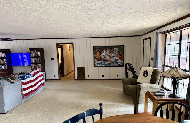 living room with crown molding, light colored carpet, and a textured ceiling