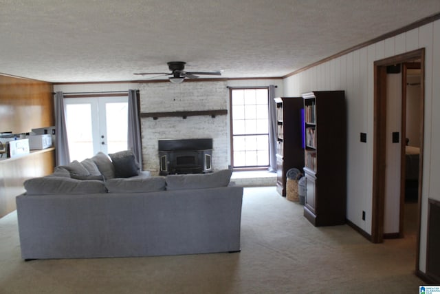 living room with french doors, crown molding, light carpet, a textured ceiling, and ceiling fan