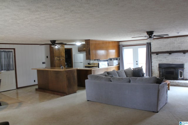 living room featuring ceiling fan, french doors, and a textured ceiling