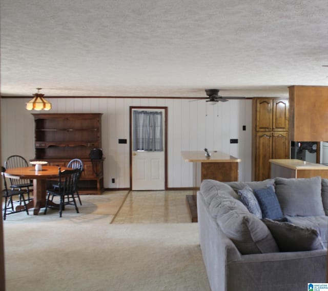 carpeted living room with ceiling fan and a textured ceiling