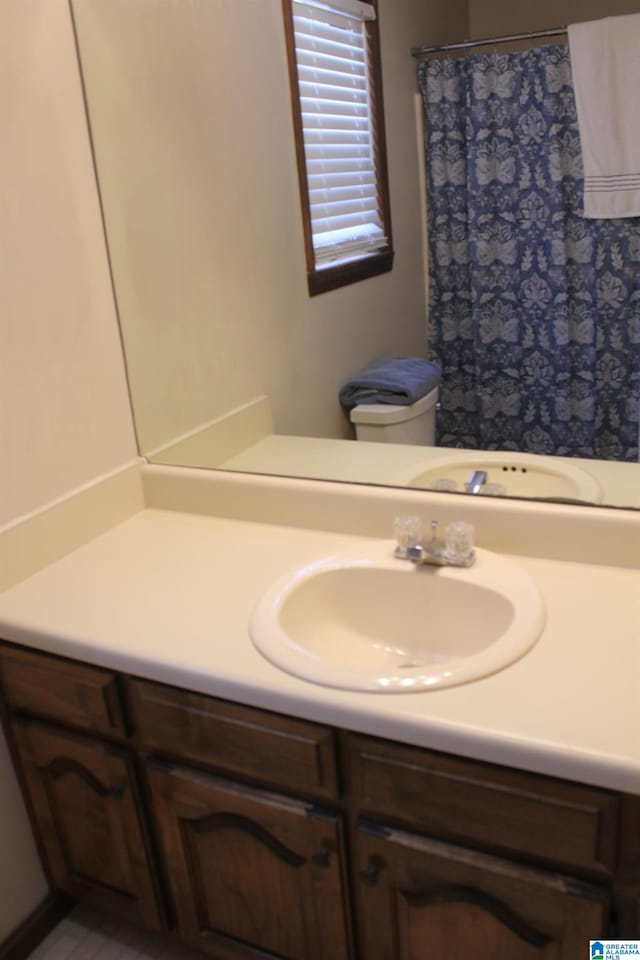 bathroom featuring walk in shower, vanity, and toilet