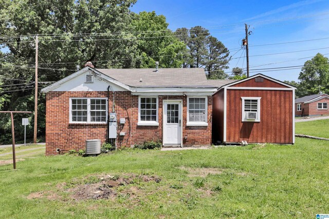212 E 28th St, Anniston, AL 36201 - view of front of home with a front yard, brick siding, and central air condition unit
