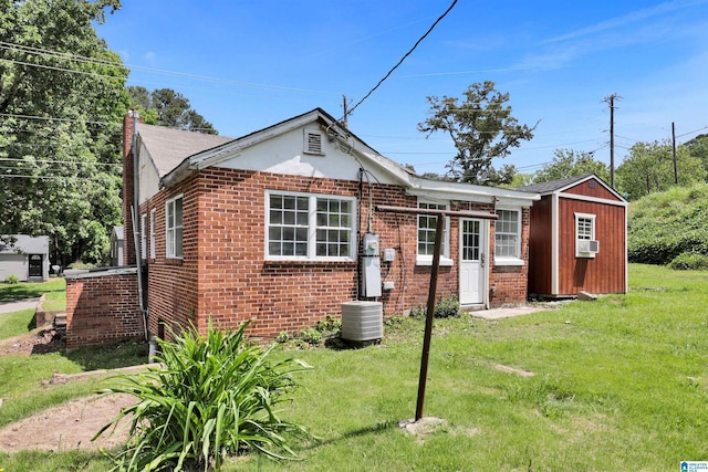 212 E 28th St, Anniston, AL 36201 - view of front of house with a front yard, brick siding, central air condition unit, a chimney, and cooling unit