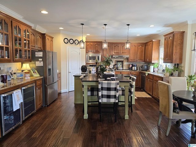 kitchen featuring an island with sink, wine cooler, and decorative light fixtures