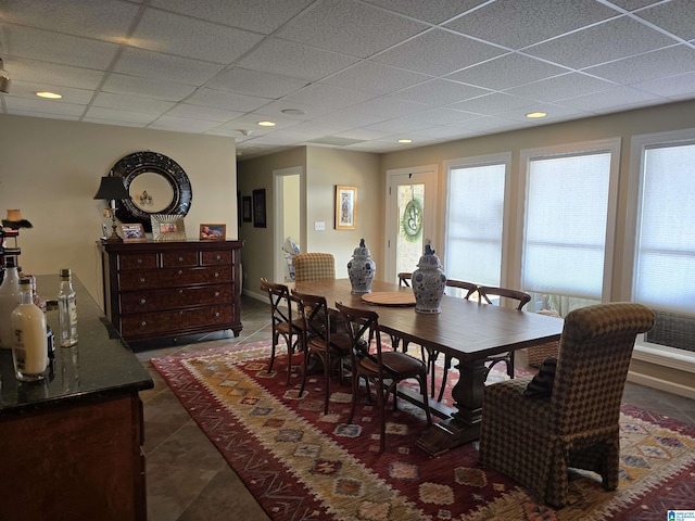 tiled dining room with a drop ceiling