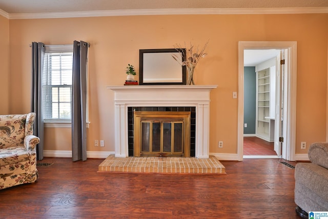 living room with a brick fireplace, ornamental molding, and dark hardwood / wood-style floors