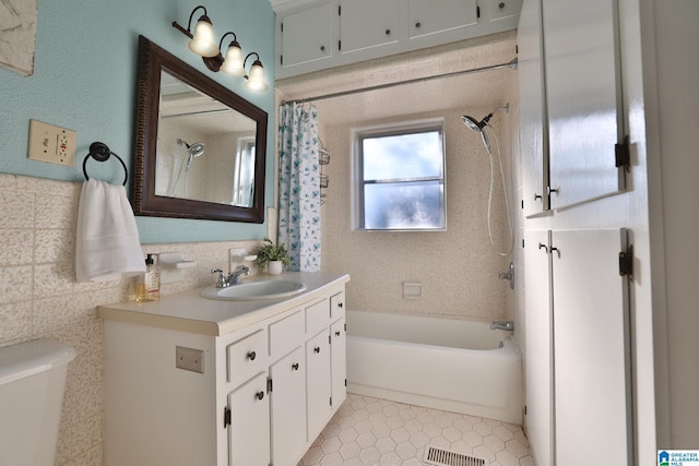 full bathroom featuring tile patterned flooring, vanity, toilet, and shower / bath combo with shower curtain