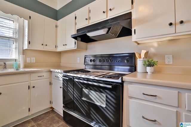 kitchen with dark tile patterned floors, sink, white cabinets, and black range with electric cooktop