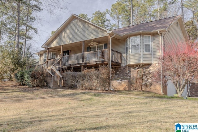 back of property with ceiling fan, a deck, and a lawn