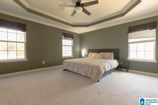 bedroom with ceiling fan, ornamental molding, a tray ceiling, and carpet flooring