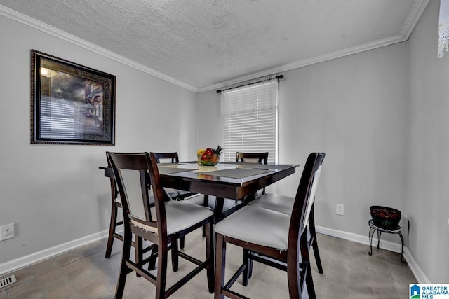 dining room featuring ornamental molding and a textured ceiling