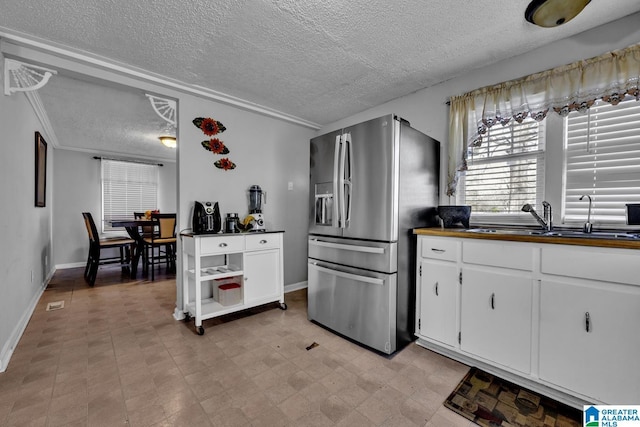 kitchen with white cabinetry, sink, a textured ceiling, and stainless steel refrigerator with ice dispenser