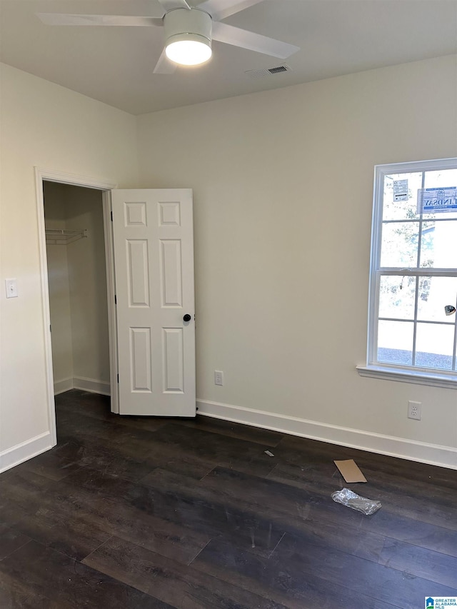 empty room featuring ceiling fan and dark hardwood / wood-style flooring