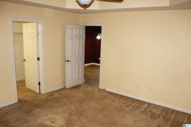 unfurnished bedroom featuring a walk in closet, a closet, and carpet flooring