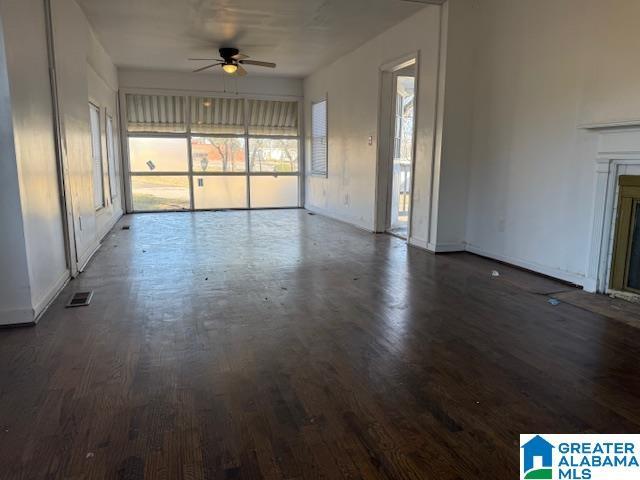 unfurnished living room with dark wood-type flooring and ceiling fan