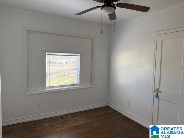 spare room featuring dark wood-type flooring and ceiling fan