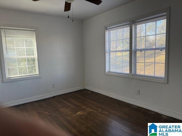 spare room with dark wood-type flooring and ceiling fan