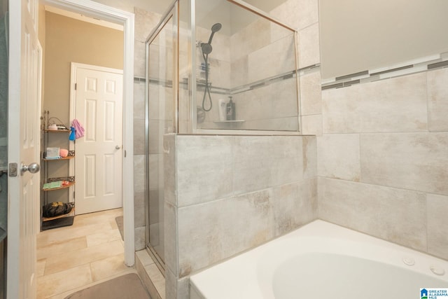 bathroom featuring shower with separate bathtub