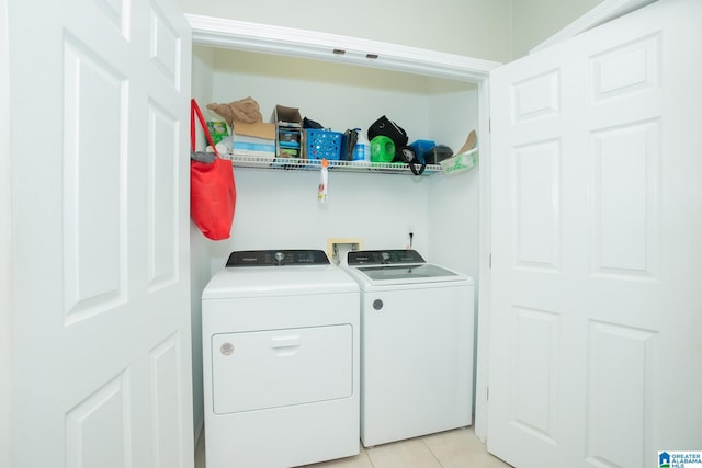 laundry area with light tile patterned floors and washer and dryer