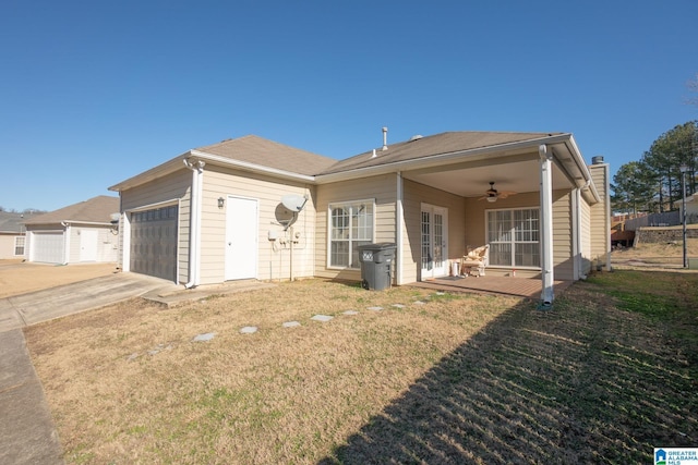 view of front of house with ceiling fan, a garage, and a front yard