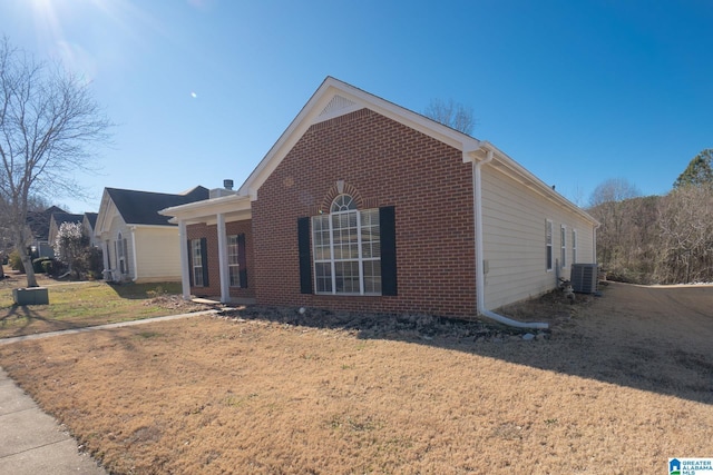 view of side of home featuring a yard and central AC unit