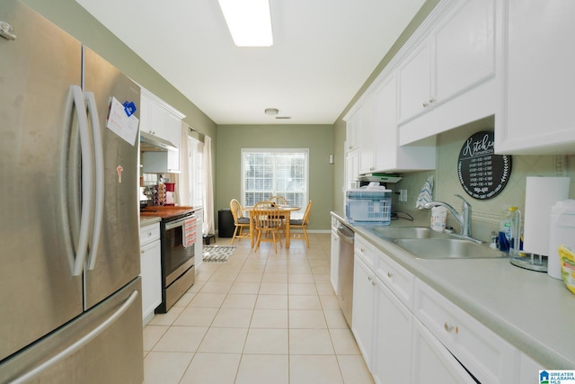 kitchen featuring white cabinetry, stainless steel appliances, sink, and light tile patterned floors