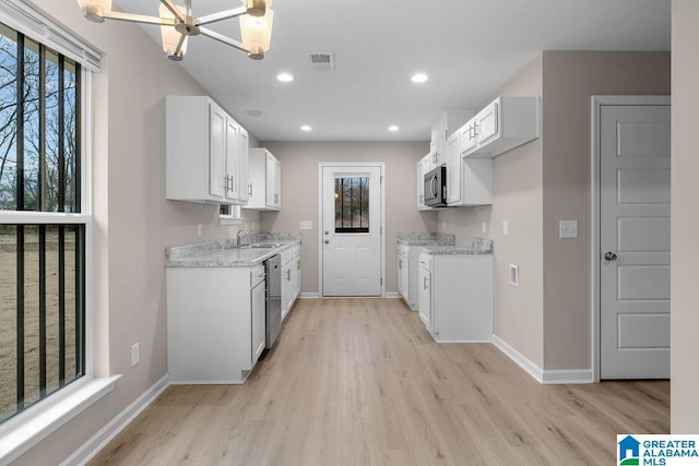 kitchen featuring white cabinetry, appliances with stainless steel finishes, light stone counters, and light hardwood / wood-style flooring