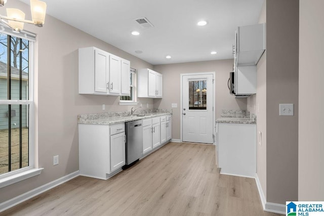 kitchen featuring sink, light hardwood / wood-style flooring, dishwasher, white cabinetry, and hanging light fixtures