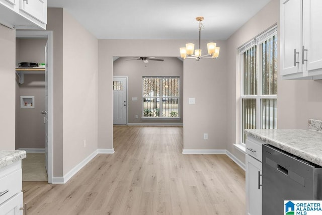 unfurnished dining area with ceiling fan with notable chandelier and light wood-type flooring