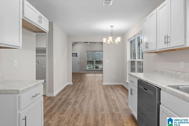 kitchen featuring ceiling fan with notable chandelier, stainless steel dishwasher, white cabinets, and decorative light fixtures