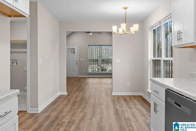 kitchen with white cabinetry, hanging light fixtures, light wood-type flooring, dishwasher, and ceiling fan with notable chandelier