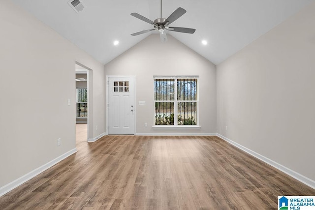 unfurnished living room featuring lofted ceiling, hardwood / wood-style floors, plenty of natural light, and ceiling fan