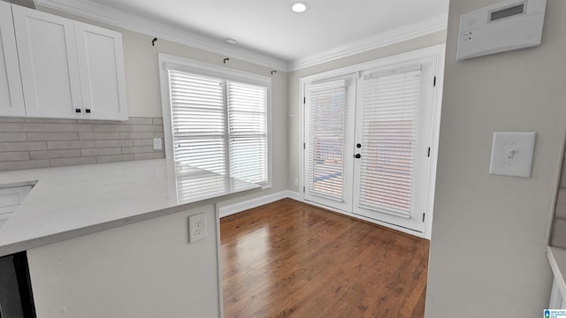 unfurnished dining area with crown molding and dark hardwood / wood-style floors