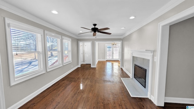 unfurnished living room featuring a tiled fireplace, dark wood-type flooring, ornamental molding, and ceiling fan