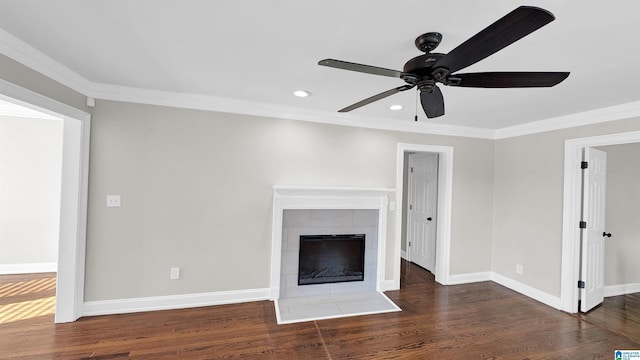 unfurnished living room featuring a tile fireplace, crown molding, dark hardwood / wood-style floors, and ceiling fan