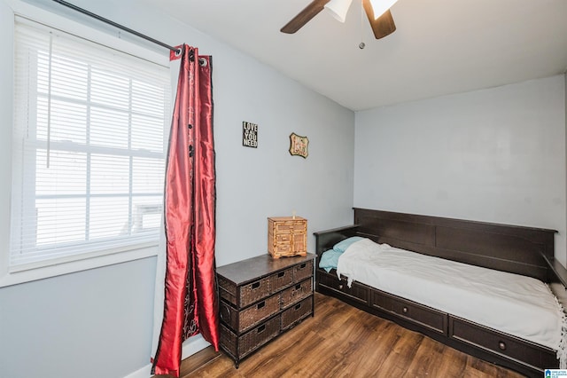 bedroom with dark hardwood / wood-style flooring and ceiling fan