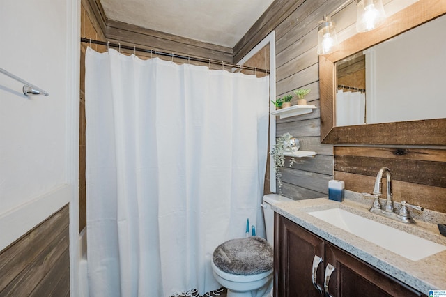 bathroom with vanity, toilet, and wood walls