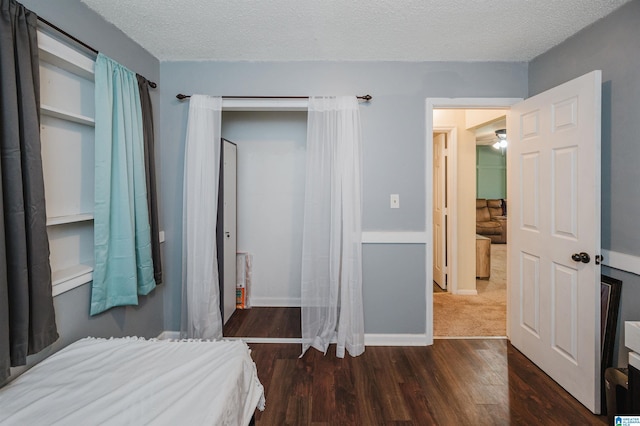 bedroom with dark wood-type flooring and a textured ceiling