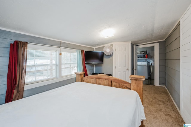 carpeted bedroom featuring washer and clothes dryer and wood walls